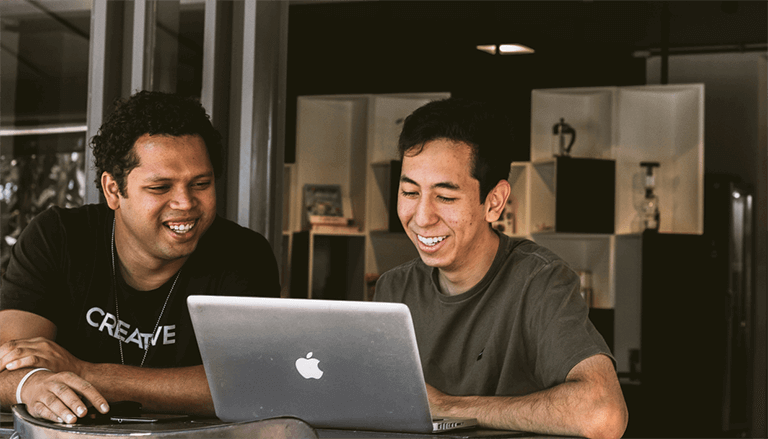 Friends Smiling at Laptop